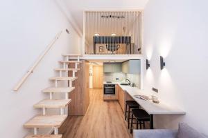 a small kitchen with a staircase in a loft at City Sky Loft in Vilnius in Vilnius