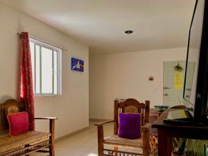 sala de estar con sillas, mesa y ventana en Departamento completo y nuevo, en San Luis Potosí