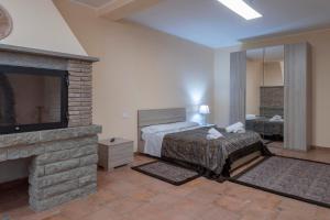 ein Schlafzimmer mit einem Kamin, einem Bett und einem TV in der Unterkunft AIR B&B PLEASANT MOMENTS in Bolsena