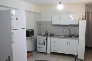 エスケルにあるEl Arrayan Departamentoのキッチン(白いキャビネット、白い冷蔵庫付)