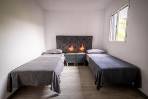 een kamer met 2 bedden en een bureau met 2 lampen bij Panoramic House in Quinta do Almeida