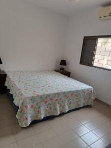 um quarto com uma cama com um cobertor florido em Casa com ótima localização e lazer espetacular. em Sao Jose do Rio Preto