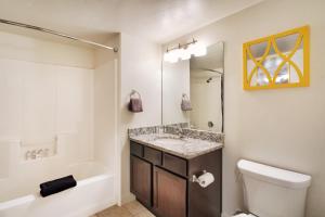 La salle de bains est pourvue d'un lavabo, de toilettes et d'une baignoire. dans l'établissement 6A Family Friendly RedCliff Condo POOL & HOT TUB (Pet Friendly), à Moab