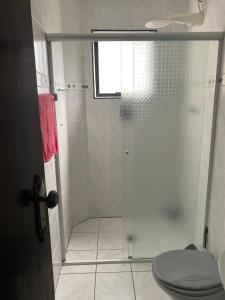 uma casa de banho com chuveiro e WC em Apartamento beira mar Centro da cidade WiFi grátis em Mongaguá