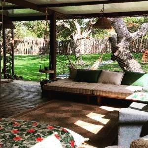 - un canapé installé sur une terrasse couverte avec une balançoire dans l'établissement Casa Gori, à Barra Grande