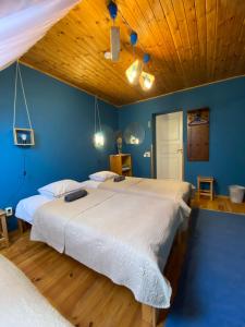 1 dormitorio con 2 camas y techo de madera en Dzintara Pirts, en Vilgāle