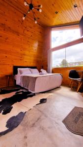 a bedroom with a bed in a wooden room at Alma de campo - hospedagem para casais e famílias e amigos in Rio Rufino