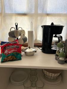 uma prateleira com uma cafeteira e um saco de comida em La Legal EQS em Esquel