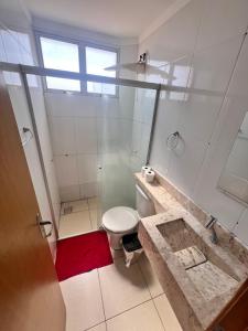 a white bathroom with a toilet and a sink at Apartamento 2 quartos mobiliado in Três Lagoas