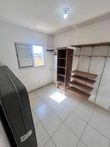 a room with a room with shelves and a suitcase at Apartamento 2 quartos mobiliado in Três Lagoas