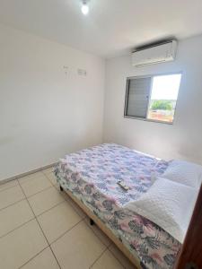 a bedroom with a bed in a room with a window at Apartamento 2 quartos mobiliado in Três Lagoas