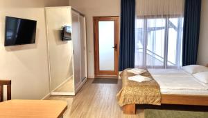a hotel room with a bed and a sliding glass door at Antano Vila in Palanga
