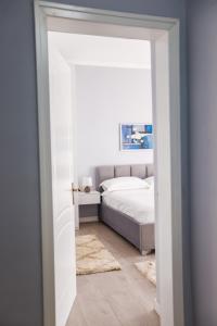 een witte slaapkamer met een bed en een witte vloer bij Viewpoint Central apartment in Tirana