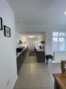 a large kitchen with white walls and a white floor at Nunnery lane 3 bedroom house in York