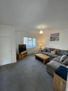 a living room with a couch and a tv at Nunnery lane 3 bedroom house in York