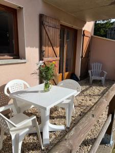 a white table and chairs on a patio at Super Besse chez Sophie 2ch, séjour, wifi, 2tv, rdc, terrasse, parc, piscine, pkg in Besse-et-Saint-Anastaise