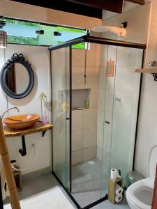 een badkamer met een douche, een wastafel en een toilet bij Eco Cabana a 150 metros da praia e centrinho in Paraty