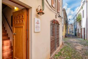 un callejón con una puerta y un cartel en un edificio en Sa Domo Apartments, en Alghero