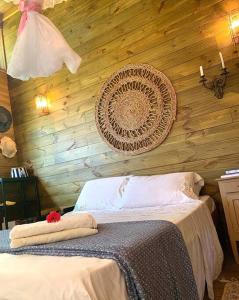 een slaapkamer met een bed met een houten muur bij Eco Cabana a 150 metros da praia e centrinho in Paraty
