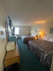 a hotel room with two beds and a desk at Blackstone Hotel in Mandan