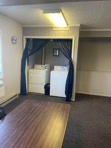 an empty room with a refrigerator and blue curtains at Blackstone Hotel in Mandan