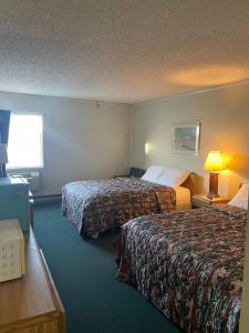 a hotel room with two beds and a window at Blackstone Hotel in Mandan