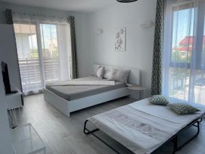 a bedroom with two beds and a large window at MIKA Studios in Eforie Nord