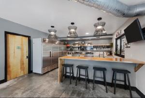 a kitchen with a bar with stools in it at Boxcar One Family Staycation Suite in Pacific