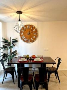 een eetkamer met een tafel en een klok aan de muur bij Departamento moderno en Guadalajara in Guadalajara