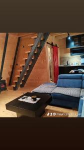 Zimmer mit einer Treppe, einem Sofa und einem Tisch in der Unterkunft Mountain spa Yin&Yang in Ledinci