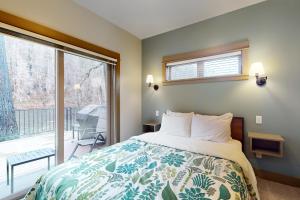 1 dormitorio con cama y ventana grande en Osprey Nest Cabin, en Vida