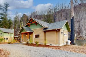 una casa en un camino al lado de una montaña en Osprey Nest Cabin, en Vida