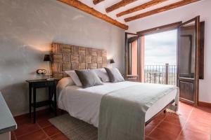 a bedroom with a large bed and a balcony at Hotel Rural La Sal in Salinas de Hoz