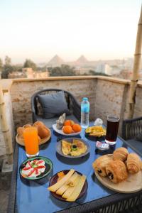 einen blauen Tisch mit Teller mit Speisen und Getränken in der Unterkunft King Tout Hotel Pyramids view in Kairo