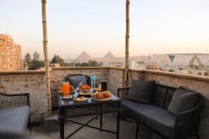 ein Tablett mit Speisen auf einem Tisch auf einem Balkon in der Unterkunft King Tout Hotel Pyramids view in Kairo