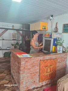 a woman standing at a counter in a kitchen at Maydã in Praia Grande