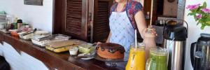a woman standing in a kitchen with a table with food at Portal Vida chalé na praia da Taiba in São Gonçalo do Amarante +16 photos