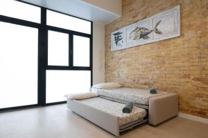 NEW BEACH flats VALENCIA في فالنسيا: غرفة نوم بسريرين وجدار من الطوب