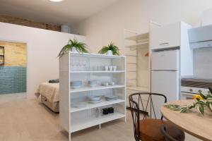 a kitchen with a white shelving unit with dishes at NEW BEACH flats VALENCIA in Valencia