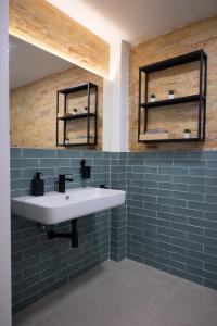 a bathroom with a white sink and blue tiles at NEW BEACH flats VALENCIA in Valencia