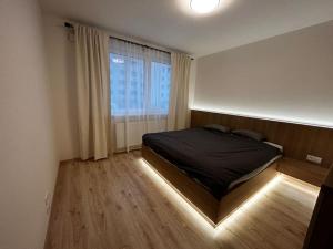 a bedroom with a bed and a large window at Brand New 2 Bedroom apartment by the airport in Bratislava