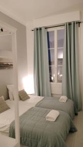 una camera con due letti e una finestra di Appartement avec belle vue sur la place du Martroi a Orléans