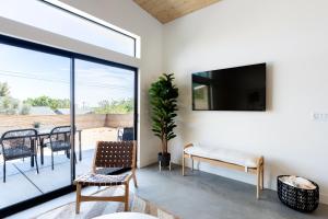 a living room with a tv and a table and chairs at Modern Joshua Tree Village Home in Joshua Tree