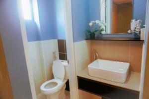 a bathroom with a white toilet and a sink at ALTEAN Apartments - Lydia Room in Manila