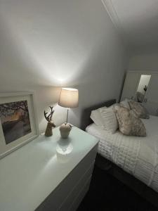 a bedroom with a bed and a lamp on a table at Albert House in Airdrie