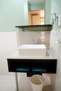 a bathroom with a white sink and a mirror at ALTEAN Apartments - Lourdes Room in Manila