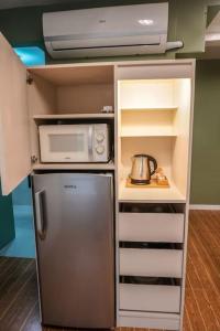 a kitchen with a refrigerator and a microwave at ALTEAN Apartments - Lourdes Room in Manila