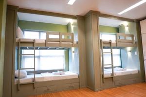 two bunk beds in a room with two mirrors at ALTEAN Apartments - Lourdes Room in Manila +15 photos