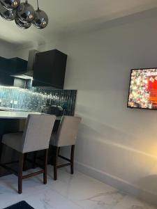 a kitchen with a table and chairs and a painting on the wall at Albert House in Airdrie +18 photos