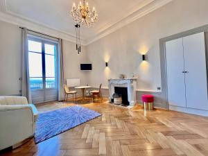 ein Wohnzimmer mit einem Tisch und einem Kamin in der Unterkunft Appartement bourgeois avec terrasse et vue lac in Aix-les-Bains